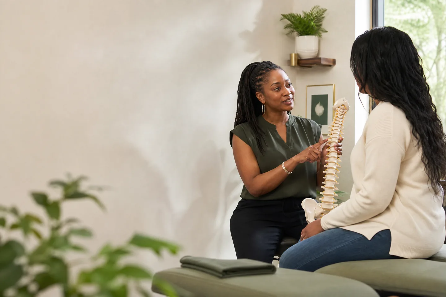 A chiropractor discussing spinal health with a patient in a calm treatment room